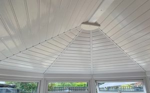 Interior view of insulated conservatory roof installation with white uPVC ceiling panels